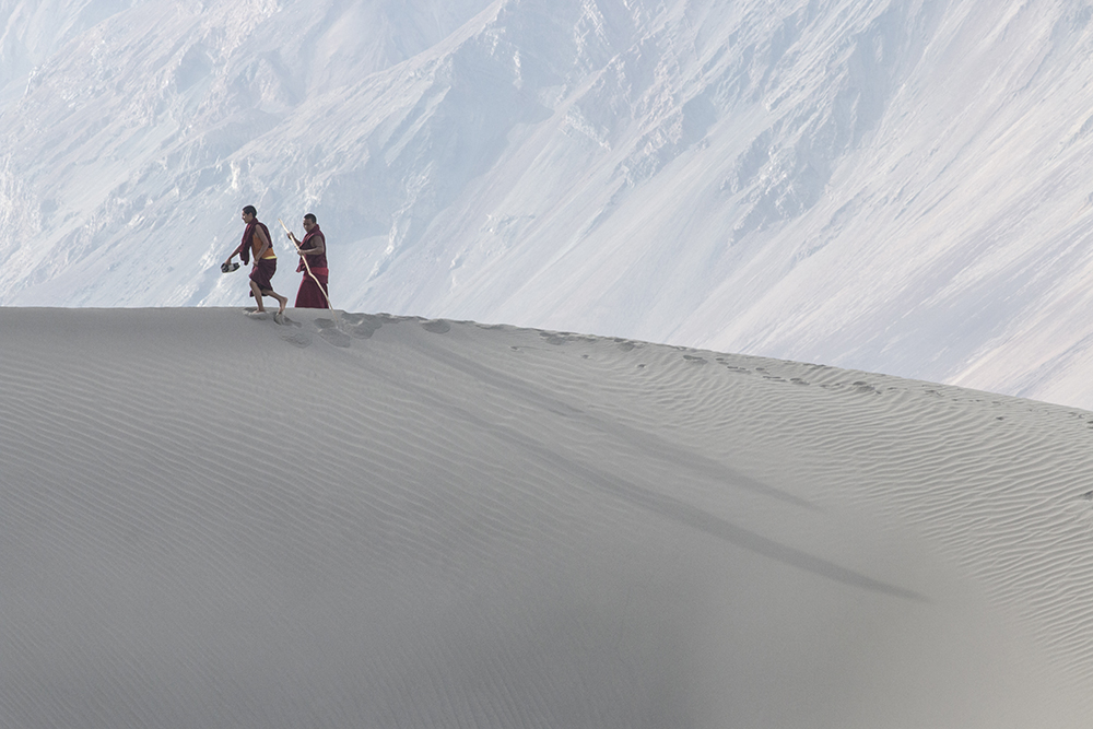 Two Monks walking on the sand dunes in Nubra Valley, Ladakh